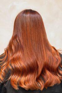 Autumnal chestnut brunette hair colour with soft waves at Mojo Hair & Beauty Chorley